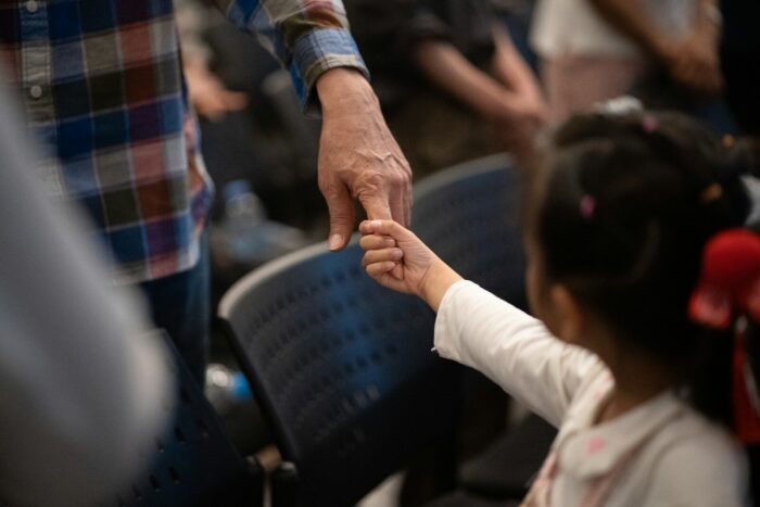 Adult hand holding a child's hand