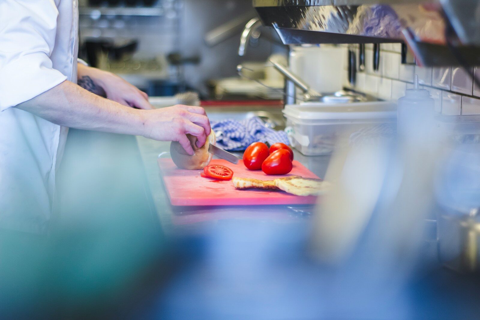 person slicing tomatoes - catering kitchen