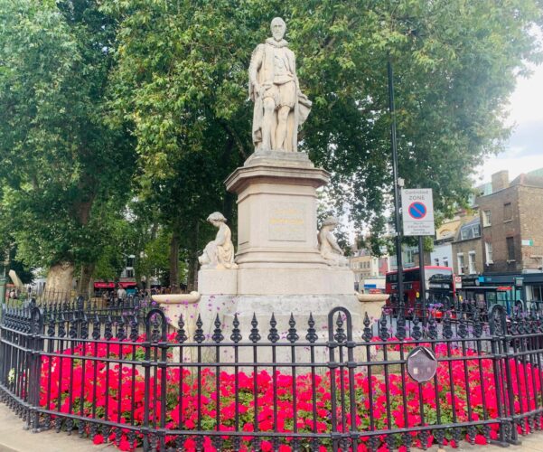 Statue on Islington green surrounded by flowers